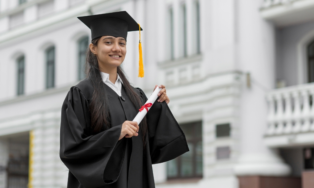 Female graduate holding a degree certificate, representing students planning to study in Germany with help from study abroad consultants in Chennai.